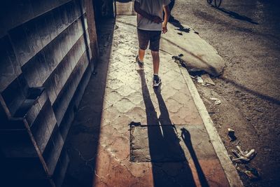 Low section of man walking on zebra crossing
