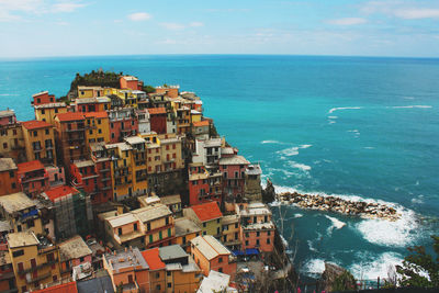 High angle view of cityscape by sea against sky