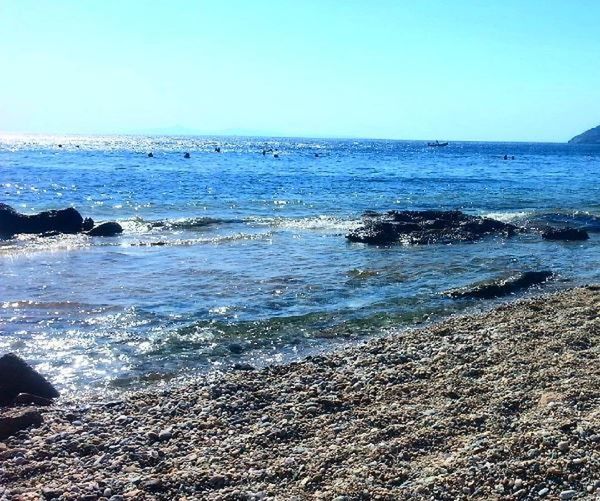 water, sea, beach, land, scenics - nature, sky, beauty in nature, horizon, horizon over water, motion, tranquility, wave, nature, tranquil scene, day, blue, rock, no people, clear sky, outdoors, power in nature