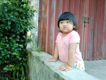 Portrait of cute girl sitting in pink clothing