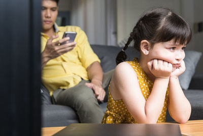 Angry girl sitting with father at home