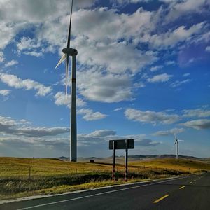 Road amidst field against sky