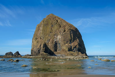 Rock formation on beach against sky