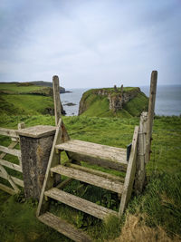 Wooden fence on field against sky