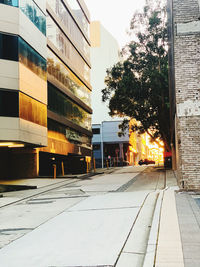 Street by buildings in city against clear sky