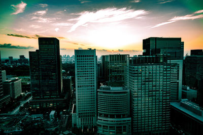 Skyscrapers in city at sunset