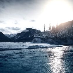 Scenic view of sea and snowcapped mountains against sky