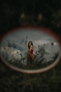 Young woman with reflection in water