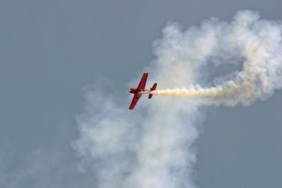 Low angle view of airplane flying against sky