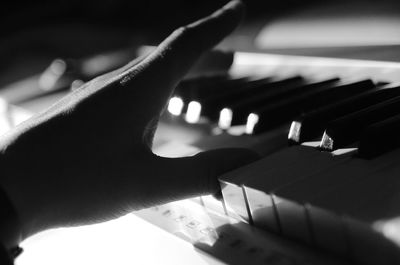 Close-up of hand playing piano