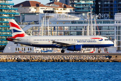 Airplane flying over sea in city