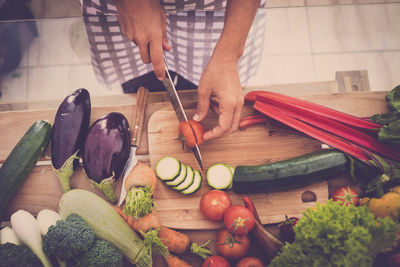 Midsection of person cutting vegetables at home