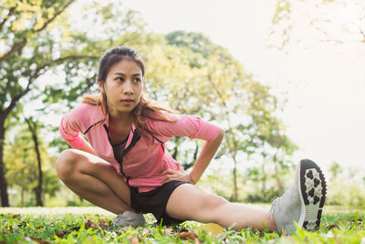 Portrait of young woman sitting against plants