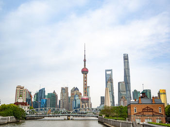 Modern buildings in city against cloudy sky