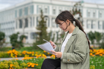 Side view of young woman using digital tablet