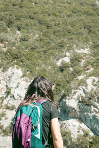 Rear view of woman standing by tree against mountain