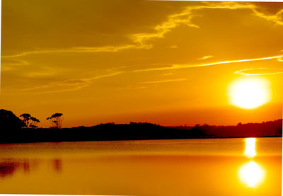 Scenic view of lake against romantic sky at sunset