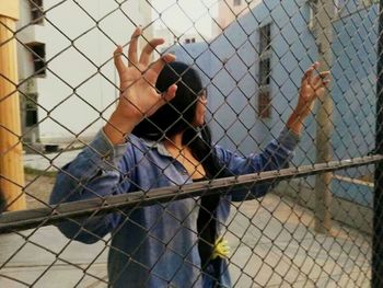 Reflection of man on chainlink fence