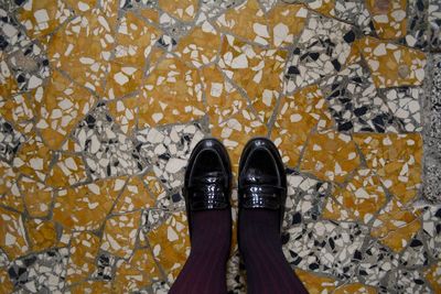 Low section of woman standing on tiled floor