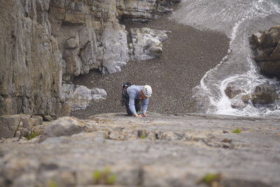 Rear view of people standing on rock formation