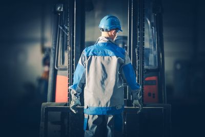 Rear view of manual worker working at factory