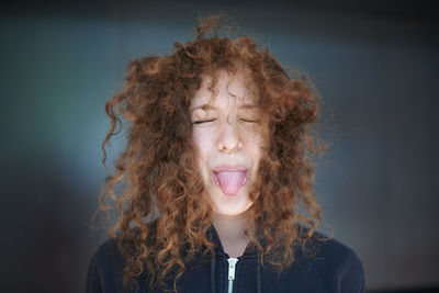 Young woman sticking out tongue