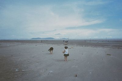 People walking on beach against sky