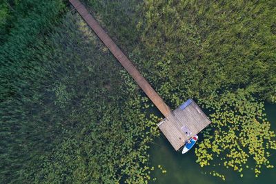 Drone shot of the wooden pier, with a sup and the lake in mazury, poland.