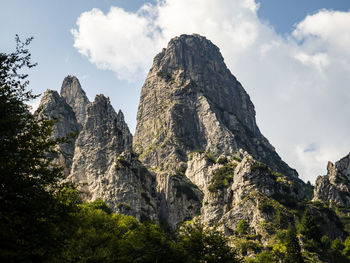 Low angle view of rocks on mountain against sky