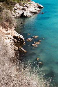 Rock formation by sea against sky 