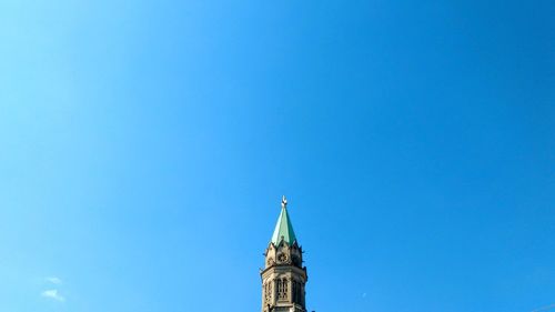 Low angle view of clock tower against blue sky