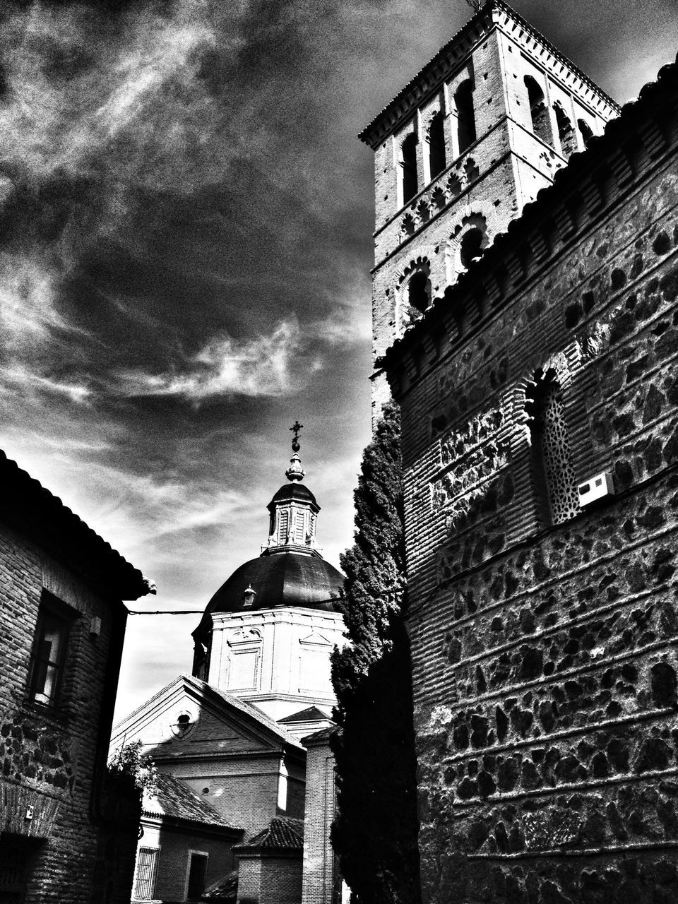 architecture, building exterior, built structure, low angle view, sky, building, residential building, residential structure, window, city, tower, cloud - sky, day, outdoors, street light, house, no people, brick wall, cloud, exterior