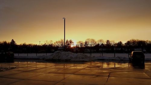 Snow covered trees against sky during sunset