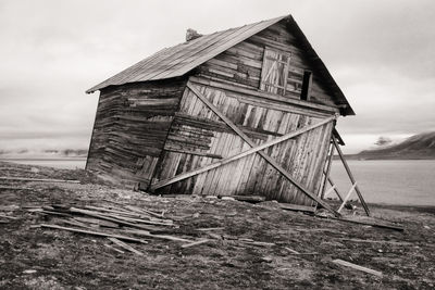 Old barn on field against sky