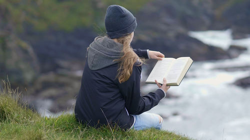 Rear view of woman reading book