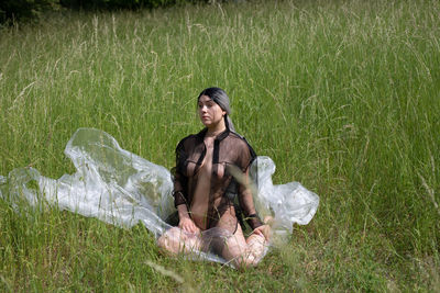 Woman sitting on grass in field