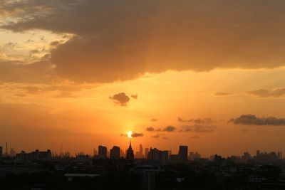 Silhouette cityscape against sky during sunset