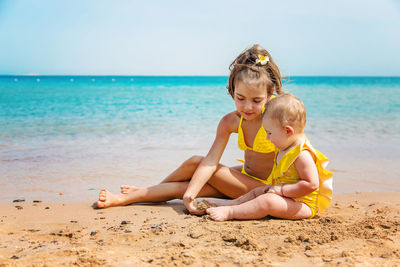 Girl with sister playing at beach