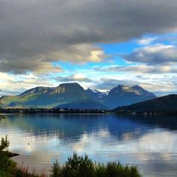 Scenic view of lake and mountains against cloudy sky