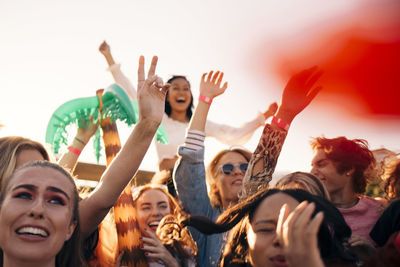 Happy men and women enjoying in music concert on sunny day