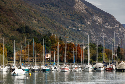 Sailboats moored on lake against mountains