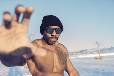 Full length of shirtless man standing on beach