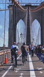 Low angle view of people walking on footbridge