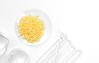 High angle view of yellow and fork over white background