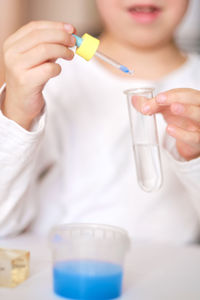 Boy is engaged in scientific research. a child with a test tube and a pipette in his hands. 