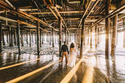 Rear view of couple standing under santa monica pier