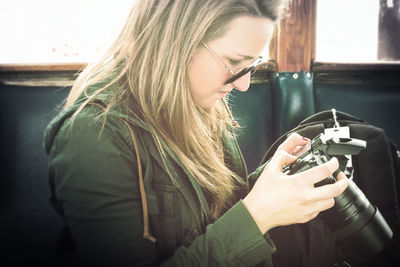 Side view of woman holding digital camera