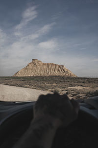 Driving through a desert. in the background a rocky mountain. selective focus.