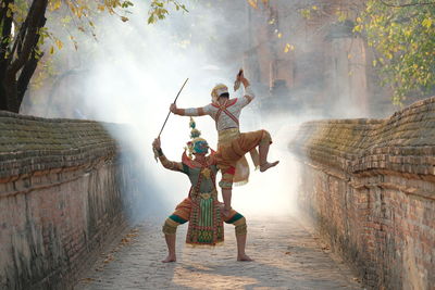 People in traditional clothing performing in alley