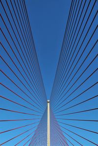 Low angle view of suspension bridge against clear blue sky